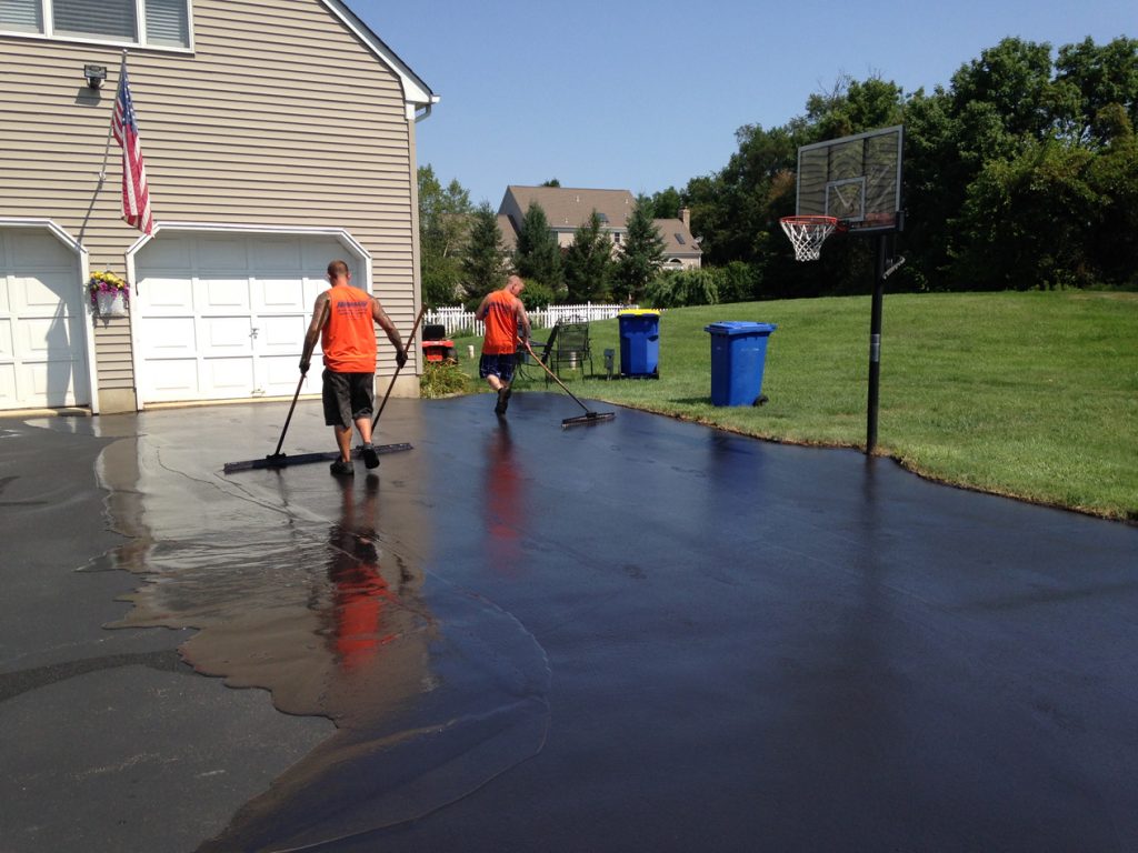 Men sealcoating driveway